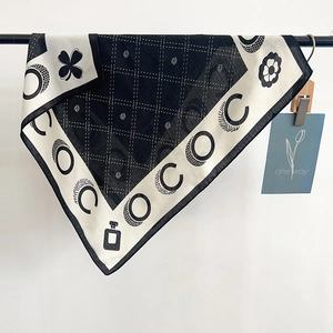 Detail of the chic black and white square scarf featuring classic letter and flower prints