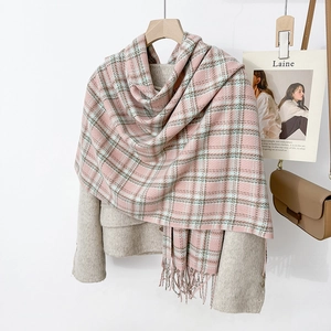 Classic pink and gray plaid scarf with tassels on gray coat for winter fashion style