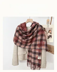 Close-up of red and brown plaid scarf with fringe detail and autumn style texture