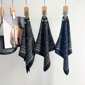 Close-up of vintage paisley square scarves in black, caramel and navy blue colors