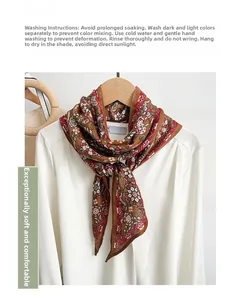 Detail of caramel brown floral silk-feel scarf tied on a white collar shirt with rolled edges