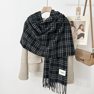 Detail of black and white checkered scarf with fringe edges and Amelyn brand label