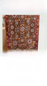 Detail of reddish-brown ethnic floral scarf with soft glossy texture and intricate patterns