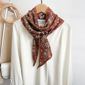 Vintage floral silk-like long scarf in reddish-brown tones draped on a white shirt