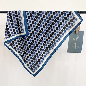 Detailansicht des dunkelblauen Polka-Dot-Seidentuchs mit seidiger Textur und Kontrastrand