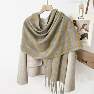 Détail de l'écharpe à carreaux gris et jaune doux avec de longues franges et texture