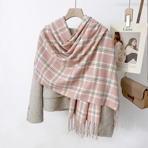 Écharpe à carreaux rose et blanc avec pompons, associée à un blazer pour un style d'hiver