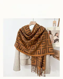 Detail shot of brown and khaki geometric scarf with tassels on a beige blazer