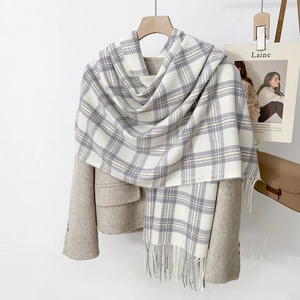 Écharpe à carreaux ivoire et violette avec franges sur un blazer pour look d'hiver