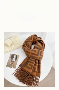 Detailed macro view of caramel cashmere-like scarf texture with jacquard patterns and tassels
