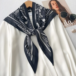 Detail of black and white paisley silk scarf with retro key patterns on a shirt