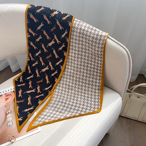 Détail du foulard twilly double face avec motif léopard et imprimés géométriques