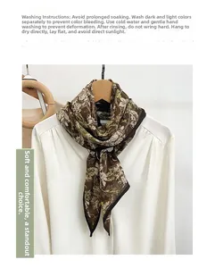 Detail view of brown silk scarf with floral print tied on a white shirt collar