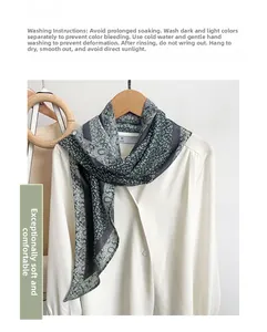 Detail of gray-green paisley silk-feel scarf draped on a white shirt collar
