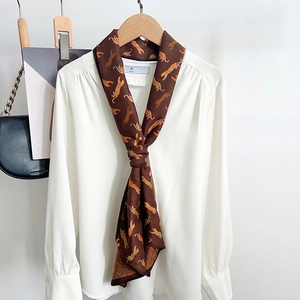 Foulard vintage en soie à motif tigre noué sur une chemise blanche pour un look élégant