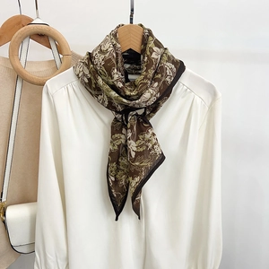 Brown floral silk-like skinny scarf with leaf patterns on elegant white shirt