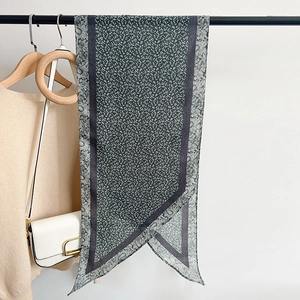 Dark grey-green floral silk scarf hanging with beige sweater and crossbody bag