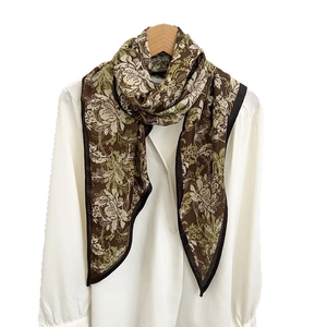 Elegant floral print long scarf tied on a shirt collar hanging from a wooden hanger