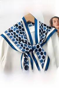 Detail of navy blue polka dot triangle scarf on a white shirt with vintage hanger