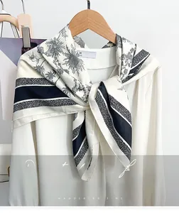 Vue détaillée d'un foulard en soie noir et blanc avec imprimé chardon et bords rayés