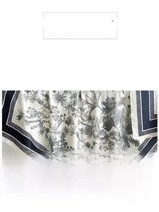 Détail d'un foulard en soie aux motifs de chardons et bordure rayée noire et blanche