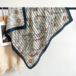 Detailed close-up of silk-feel square scarf featuring classic equestrian chain prints