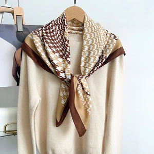 Houndstooth pattern silk scarf in brown and beige tones styled on a beige sweater
