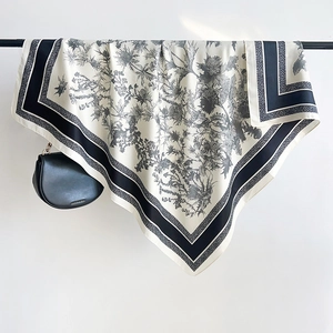 Détail d'un élégant foulard en soie à motif chardon avec bordure rayée noire et blanche