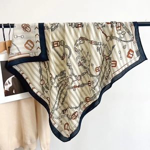 Detail of luxury silk-feel scarf featuring vintage equestrian chain and buckle pattern