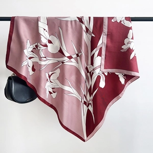 Detail of floral printed silk square scarf with fine rolled edges and red pink pattern