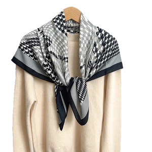 Classic houndstooth square scarf in black white and grey for women on a beige sweater