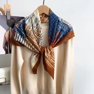 Detail showing the elegant drape of a silk-feel square scarf with abstract floral print