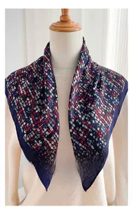 Detail of navy herringbone square scarf with colorful geometric patterns on model