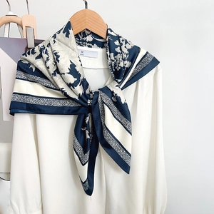 Élégant foulard en satin à fleurs bleu marine et beige porté sur une chemise en mousseline