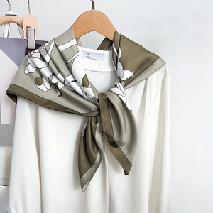 Elegant olive green and white floral silk square scarf tied on a white shirt