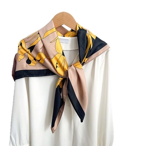 Floral imitation silk square scarf with yellow flowers on khaki background over shirt