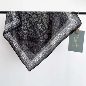 Navy paisley square silk scarf with bohemian patterns hanging on a black rack for women