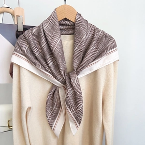 British style retro brown and white plaid scarf with striped borders on a hanger