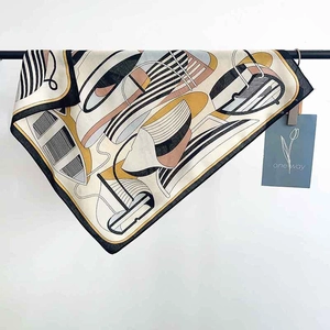 Detail view of French silk scarf with abstract sailing print and brand tag hanging on a rack