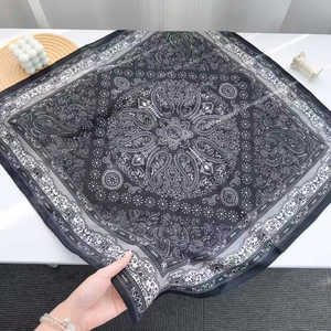Flat lay of navy blue paisley silk square scarf with elegant decorative patterns