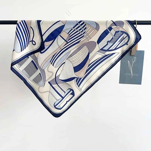 Detail of elegant blue striped silk scarf folded on a black metal hanging rack