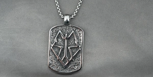 Macro shot of silver titanium steel military tag pendant with geometric wolf head pattern