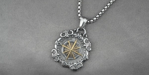 Detail view of a vintage nautical star compass pendant with gold star on a silver chain