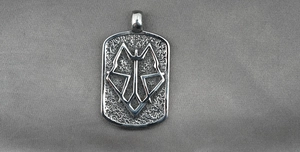 Detailed view of vintage steel dog tag pendant featuring embossed geometric wolf head totem