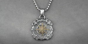 Close-up of vintage steel nautical compass pendant with gold star and rune details