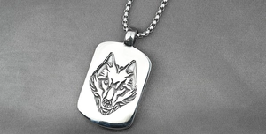 Macro view of vintage wolf head totem pendant with box chain on dark grey fabric