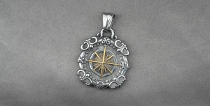 Macro detail of vintage compass pendant with gold star accent and gothic engravings
