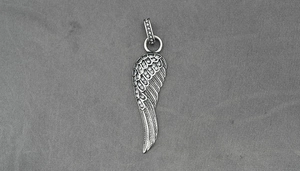 Détail macro du pendentif aile d'ange en argent avec plumes en cristal scintillantes