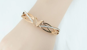 Detailed macro view of rose gold butterfly bracelet with crystal pavé and matte texture