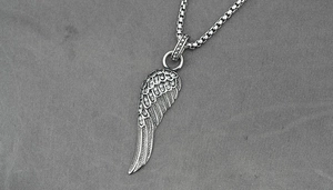Vue détaillée du collier pendentif plume orné de strass avec une finition argent vintage